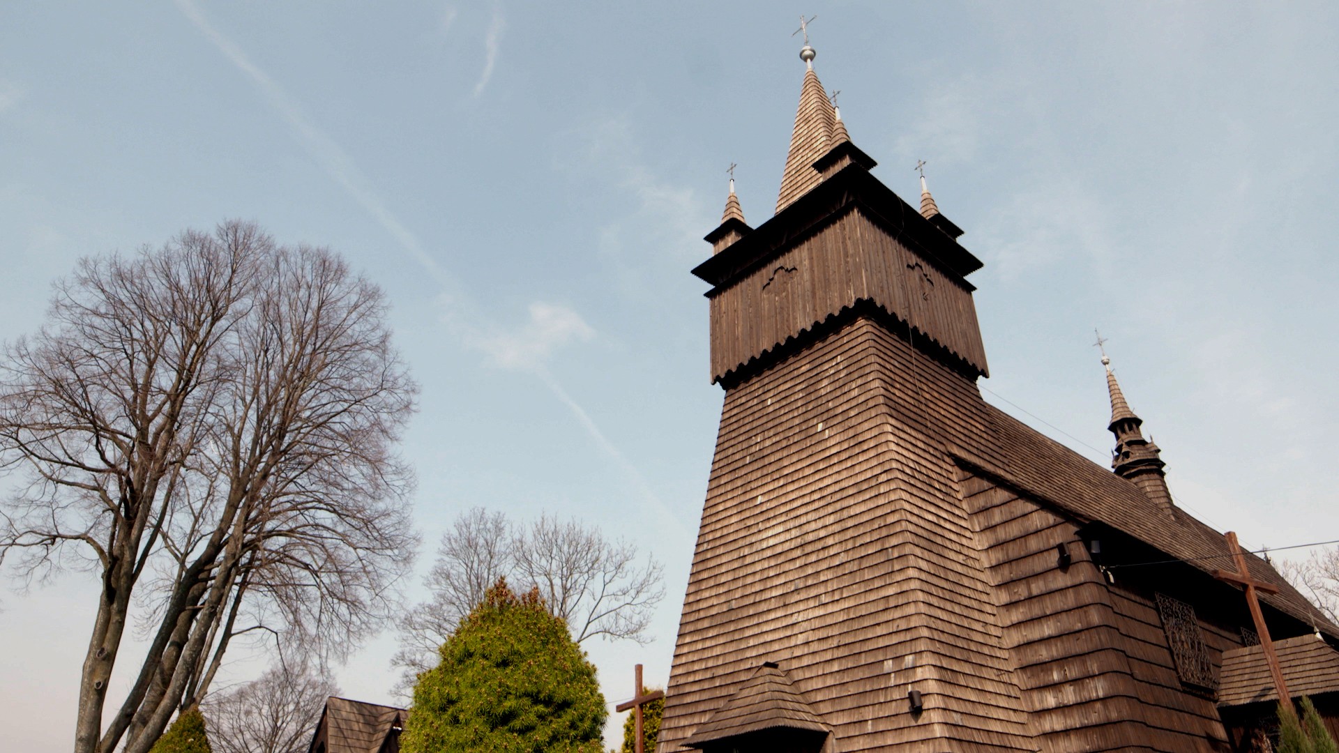 Wieża kościoła, obłożona ciemnobrązowym drewnianym gontem.